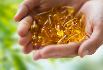 Image showing hands holding cod liver oil capsules