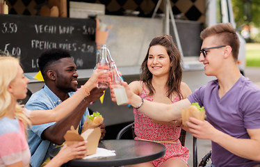 Image showing friends clinking drinks and eating at food truck