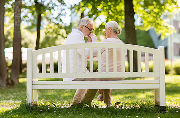 Image showing happy senior couple sitting on bench at park