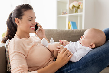 Image showing mother with baby calling on smartphone at home