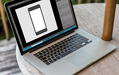 Image showing laptop with smartphone image in graphics editor