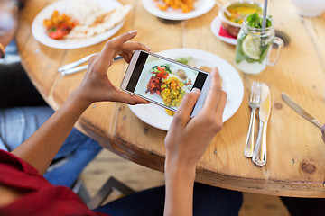 Image showing hands with smartphone picturing food at restaurant