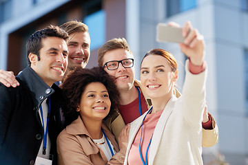 Image showing business team with conference badges taking selfie