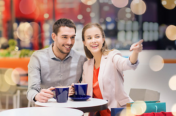 Image showing happy couple with shopping bags drinking coffee