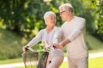 Image showing happy senior couple with bicycle at summer park