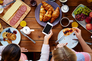 Image showing women with smartphones eating food at table