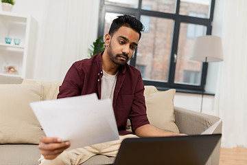 Image showing upset man with laptop and papers at home