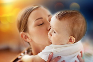 Image showing close up of happy young mother kissing little baby