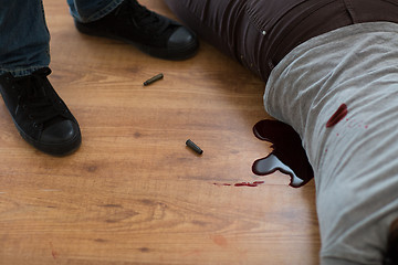 Image showing criminal with dead body and bullets at crime scene