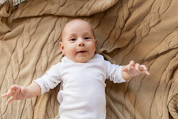 Image showing sweet little baby boy lying on knitted blanket