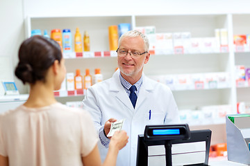 Image showing customer giving money to pharmacist at drugstore