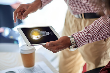 Image showing businessman with lightbulb on tablet pc at office