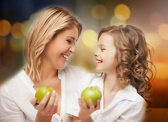 Image showing happy mother and daughter with green apples