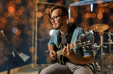 Image showing man playing guitar at studio or concert 