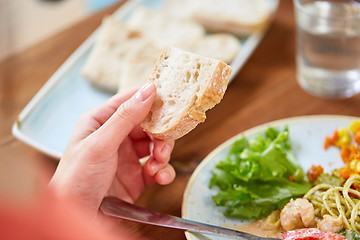 Image showing hand of woman holding piece of bread