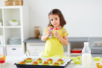 Image showing little girl in chefs toque baking muffins at home