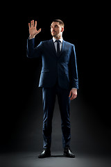 Image showing businessman in suit touching something invisible