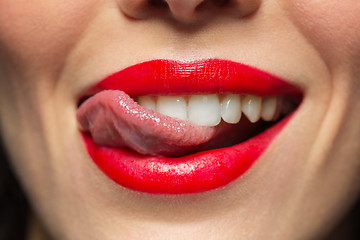 Image showing close up of woman with red lipstick licking lips