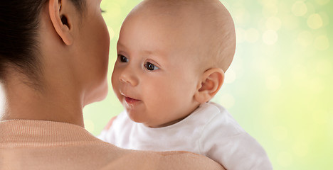 Image showing close up of happy baby with mother over green