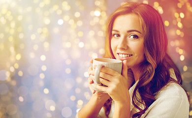 Image showing happy woman with cup of tea or coffee at home