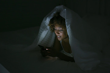 Image showing Young woman using phone in dark room