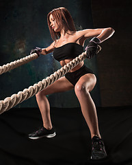 Image showing The strong young woman pulling rope at a gym