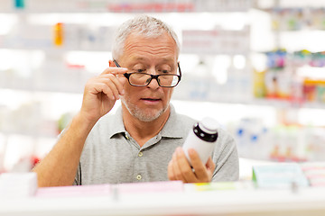 Image showing senior male customer with drug at pharmacy