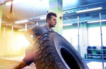 Image showing man doing strongman tire flip training in gym