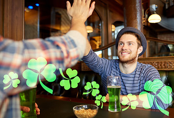 Image showing friends with green beer making high five at pub