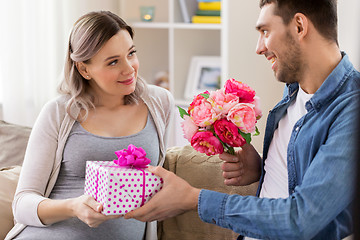 Image showing man giving flowers to pregnant woman at home