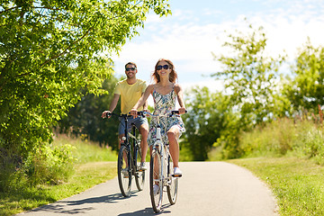 Image showing happy young couple riding bicycles in summer