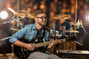 Image showing musician playing guitar at studio over lights