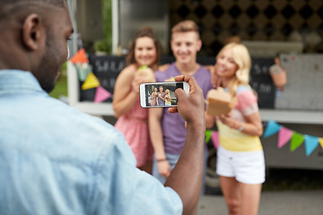 Image showing man taking picture of friends eating at food truck