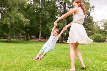 Image showing happy mother playing with baby girl at summer park