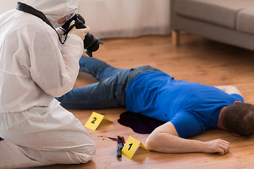 Image showing criminalist photographing dead body at crime scene