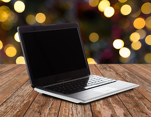 Image showing laptop with black screen over christmas lights