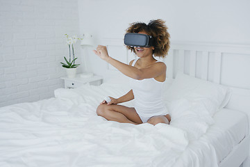 Image showing Content woman in VR glasses on bed