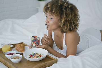 Image showing Dreaming woman having sweet meal in bed