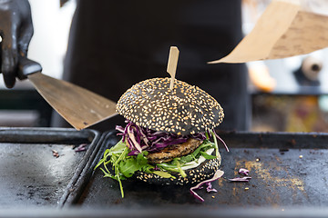 Image showing Chef preparing burgers at grill plate on international urban street food festival.