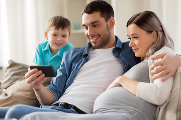 Image showing happy family with smartphone at home