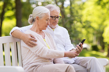 Image showing happy senior couple with smartphone at park