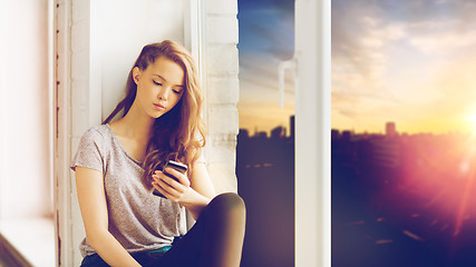 Image showing sad pretty teenage girl with smartphone texting