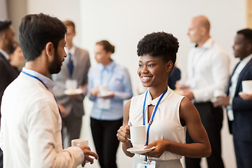 Image showing business people with conference badges and coffee