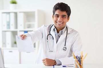 Image showing happy doctor with prescription at clinic