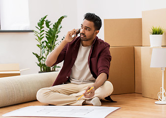 Image showing man with blueprint and boxes moving to new home