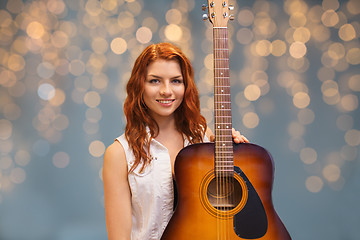 Image showing female musician with guitar over lights background