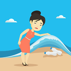 Image showing Woman showing plastic bottles under sea wave.