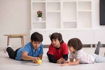 Image showing boys having fun with an apple on the floor