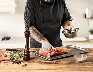 Image showing Man cooking meat steak on kitchen
