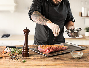 Image showing Man cooking meat steak on kitchen